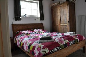 een slaapkamer met een bed met een kleurrijke deken bij B&B Kelpiebrink in Baarle-Nassau