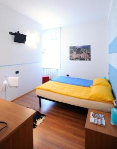 a bedroom with a bed with yellow sheets and a desk at APPARTAMENTS SUPERIOR ,o SUITE GARDARCO in Arco