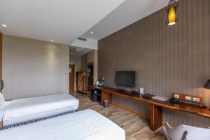 a hotel room with two beds and a television at Hualien Toongmao Resort in Jian