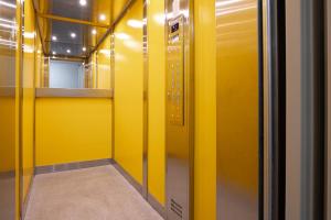 a hallway with yellow walls and a yellow elevator at Apartmány a Studia Zámecký park in Litvínov