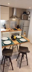 a kitchen with a table with plates on it at LE COSY Joli F2 proche gare, Arénes avec terrasse privée in Nîmes +13 photos