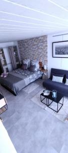 uma sala de estar com uma cama e um sofá em LE COSY Joli F2 proche gare, Arénes avec terrasse privée em Nîmes