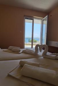 a room with three beds with towels in the shape of hearts at Villa Marić in Baška Voda