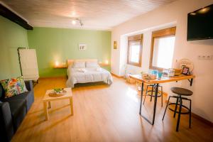 ein Wohnzimmer mit einem Bett und einem Tisch in der Unterkunft O Noso Recuncho in Palas de Rei