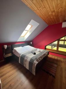 a bedroom with a bed with a red wall at Dom na wynajem Mazury DOM NA WYSOKIM BRZEGU in Nowe Bagienice +34 photos