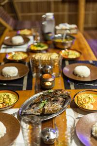 uma longa mesa de madeira com pratos de comida em TABARI DIVE LODGE em Pulau Mansuar