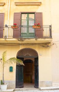 un ingresso a un edificio con balcone e porta di Civico64 apartments a Castellammare del Golfo