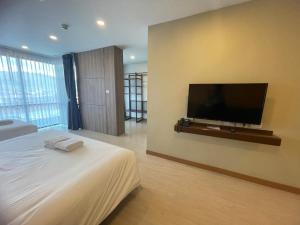 a bedroom with a flat screen tv on the wall at The Vita Plus Hotel in Hat Yai