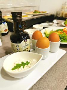 une assiette blanche avec des œufs et un bol de riz dans l'établissement Platinum Ostróda, à Ostróda