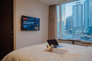 a hotel room with a laptop on a bed with a window at LOTTE CITY HOTEL Mapo in Seoul