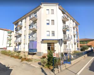 un edificio blanco con balcones en una calle en Resp Suites Novara, en Novara