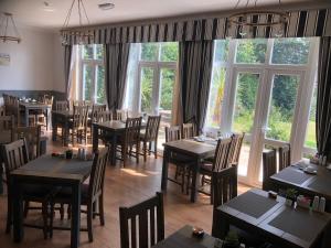 a dining room with tables and chairs and windows at The Havelock in Shanklin