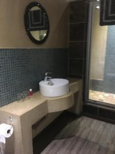 a bathroom with a sink and a mirror at Damascus Bush Lodge in Hartbeespoort