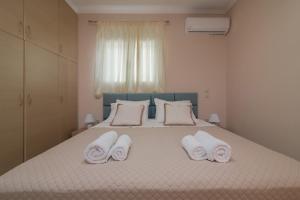 a bedroom with a bed with towels on it at Taso's Modern House! in Zakynthos Town