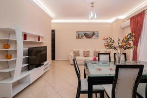 een woonkamer met een tafel, een bank en een televisie bij Taso's Modern House! in Zakynthos