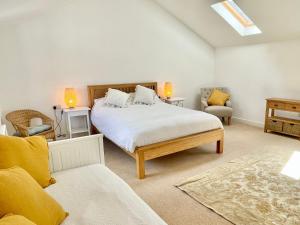 um quarto com uma cama grande e 2 cadeiras em Rye Court Cottage - Stunning cottage in central Helmsley with parking em Helmsley