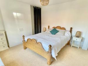 a bedroom with a wooden bed and a window at The Old Post Office - central Helmsley with parking in Helmsley