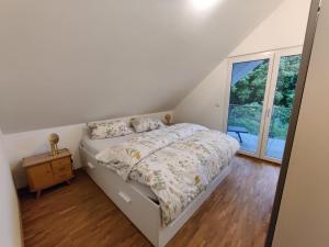 a white bedroom with a bed and a window at N13 Living in Wangen im Allgäu