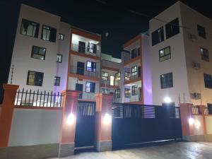 ein Gebäude mit einem Zaun in der Nacht davor in der Unterkunft Washington Court - Deluxe One Bedroom Apartment in Accra