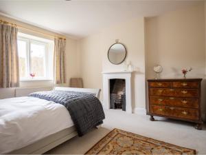 a bedroom with a bed and a mirror and a dresser at Lake Cottage in Woodchester