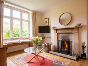 a living room with a fireplace and a tv at Lake Cottage in Woodchester