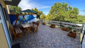 eine Terrasse mit Bänken und einem Sonnenschirm auf dem Balkon in der Unterkunft Apartman-Suite "Marinero" in Vršac