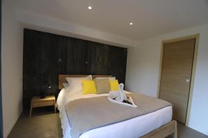 a bedroom with a large bed with yellow pillows at Hôtel confidentiel Le Grecale in Pianottoli-Caldarello