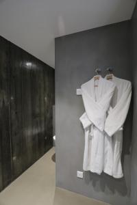 a bathroom with white towels hanging on a wall at Hôtel confidentiel Le Grecale in Pianottoli-Caldarello
