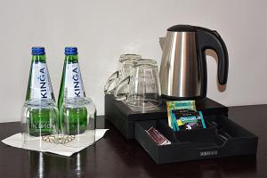 three glass bottles and a coffee maker on a table at Hotel Pod Lwem in Elblag