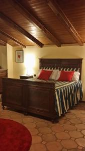 a bedroom with a large wooden bed with red pillows at Peropero' in Gattinara