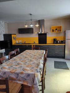 a kitchen with a table and a kitchen with yellow walls at Passion in Châteauvieux