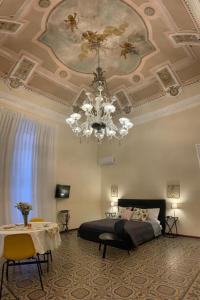 ein Schlafzimmer mit einem Bett und einer Decke mit einem Kronleuchter in der Unterkunft Lex Suites in Catania