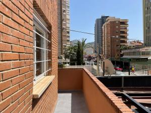 ceglany budynek z ławką na balkonie w obiekcie New Square Ocean w mieście Benidorm
