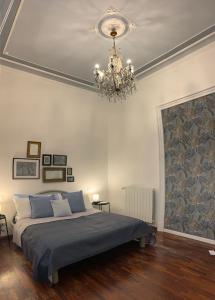 a bedroom with a bed and a chandelier at Lex Suites in Catania