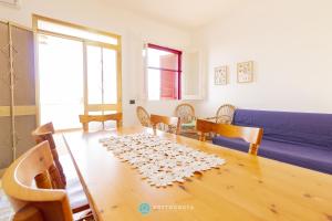 un salon avec une table et un canapé bleu dans l'établissement MACHIAVELLI FLAT - ROCA, à Roca Vecchia