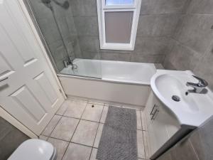 uma casa de banho com uma banheira, um lavatório e um WC. em 2 Bedroom Apartment in Kentish Town em Londres