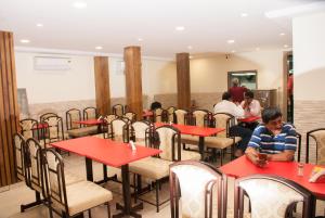 a group of people sitting at tables in a restaurant at City Hotel in Mumbai