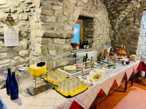 Agriturismo Montagna Verde Apella في Licciana Nardi: طاولة طويلة عليها طعام ومشروبات
