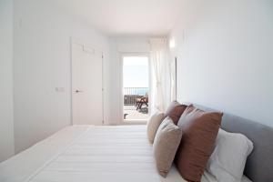 a bedroom with a bed with pillows and a window at Global Properties, Apartamento con vistas al mar, Canet d'en Berenguer in Canet de Berenguer +43 photos