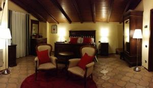 a bedroom with a bed with red pillows and chairs at Peropero' in Gattinara