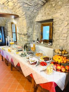 una mesa con comida en ella en una sala de piedra en Agriturismo Montagna Verde Apella, en Licciana Nardi