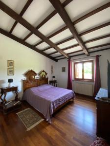 a bedroom with a large bed and wooden floors at Villa Strada dei Monti Sibillini in Montefortino