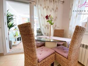 ein Esszimmer mit einem Tisch und Korbstühlen in der Unterkunft Mar menor golf detached Villa in Torre-Pacheco