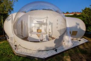 Burbujas Astronómicas Albarari Coruña في أوليروس: بيت قبة بيضاء كبير مع غرفة نوم بالداخل