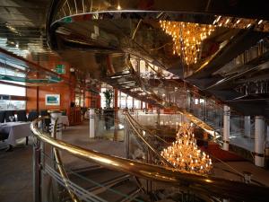 un escalier dans un restaurant orné de lustres dans l'établissement Sunborn London Yacht Hotel, à Londres