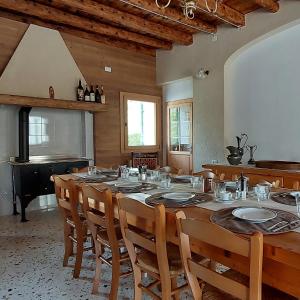 - une salle à manger avec une table, des chaises et un piano dans l'établissement Agriturismo l'Eremo, à Volpago del Montello