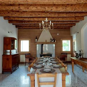 une grande salle à manger avec une grande table et un lustre dans l'établissement Agriturismo l'Eremo, à Volpago del Montello