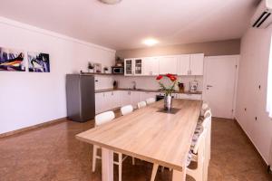 a kitchen with a wooden table and white cabinets at Large apartment in Central Istria with private pool in Pulići