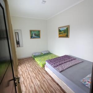 1 Schlafzimmer mit 2 Betten und 2 Bildern an der Wand in der Unterkunft Villa Names2 Gunung Bunder in Gunungpicung