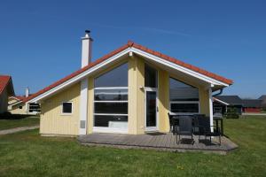 une maison dotée d'une terrasse avec deux chaises dans l'établissement Resort 2 Beach House B 47, à Großenbrode
